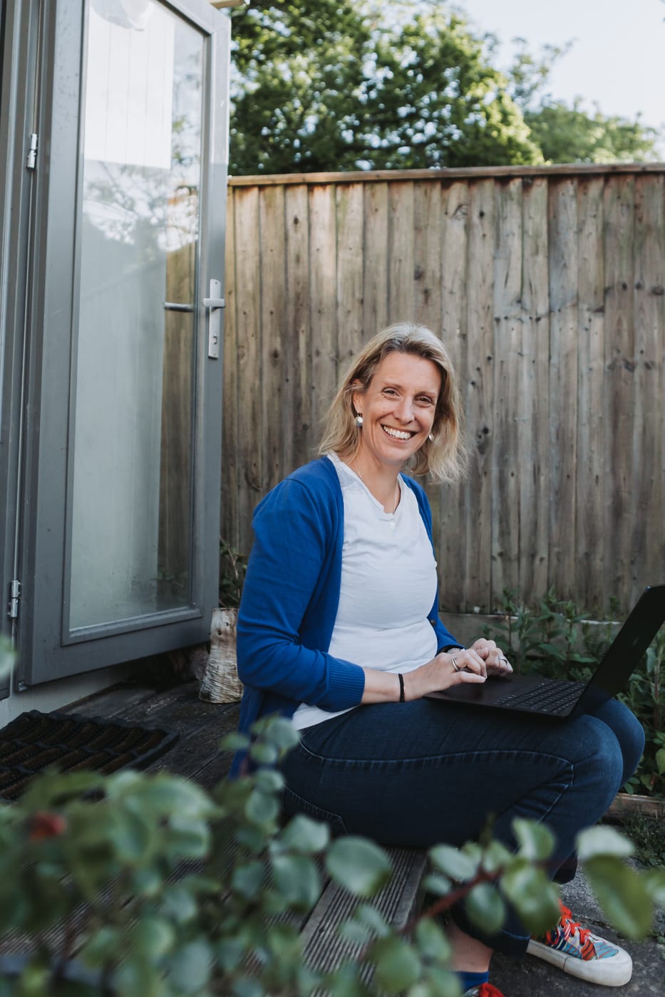 Dr Helen Ross working on a laptop outside her garden office